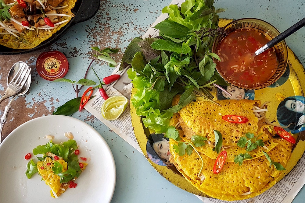 Enjoy vegan Banh Xeo with crispy crust and a full filling, dipped in sweet and sour vegetarian fish sauce
